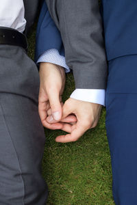 Cropped image of men lying on field