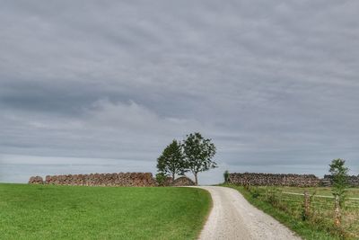 Road amidst field against sky