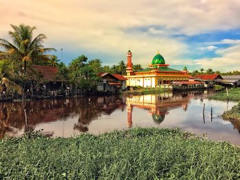 Reflection of temple in lake against sky