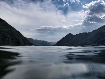 Scenic view of lake by mountains against sky