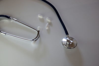 High angle view of stethoscope and medicines on gray background