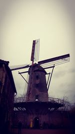 Low angle view of traditional windmill against sky