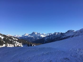 Scenic view of snowcapped mountains against clear blue sky