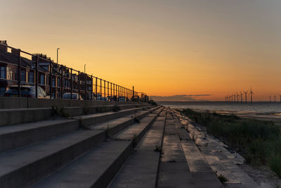 Pier over sea against sky during sunset