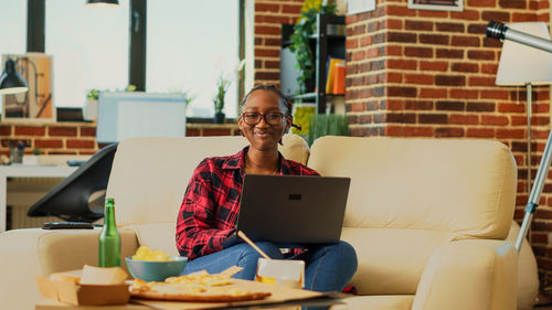 Young woman using laptop while sitting at home