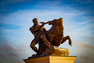 Low angle view of angel statue against sky