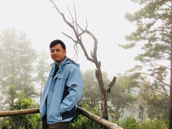 Portrait of man standing against trees