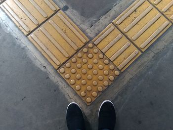 Low section of person standing tiled floor
