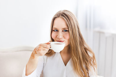 Portrait of young woman drinking coffee cup