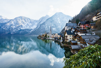 Scenic view of lake by buildings against sky