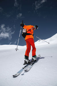 Wide angle young male athlete skier in a ski tour on skis on the background of snow-capped mountains