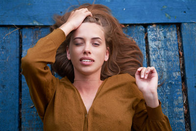 High angle view portrait of beautiful young woman lying on wood paneling