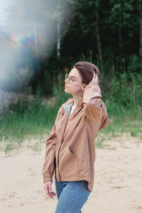 Candid close up portrait of a young woman with short hair in eyeglasses on nature