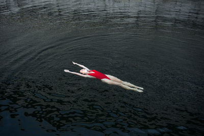 High angle view of person lying in sea
