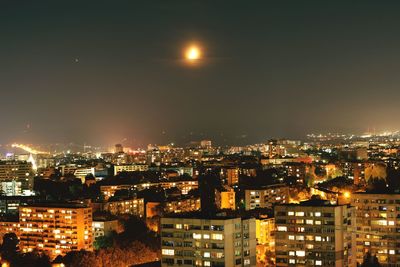 High angle view of illuminated buildings against sky at night