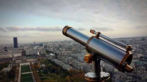 Close-up of coin-operated binoculars against cityscape