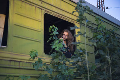 Woman standing at window of abandoned train