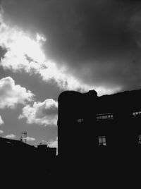 Low angle view of buildings against cloudy sky