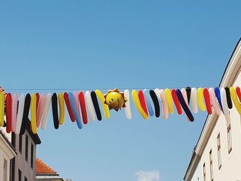 Low angle view of clothes drying against clear blue sky