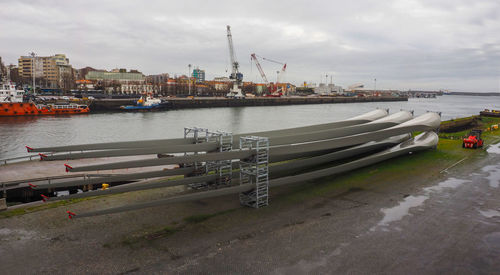 Boats moored at harbor against sky