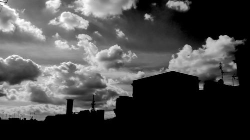 Low angle view of buildings against cloudy sky