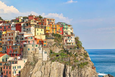 Buildings by sea against sky in city