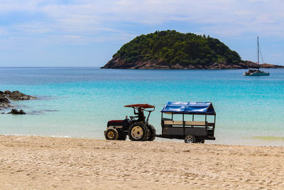 Deck chairs on beach against sky