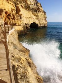 Rock formations by sea against sky