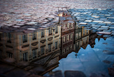 Reflection of building in puddle on street