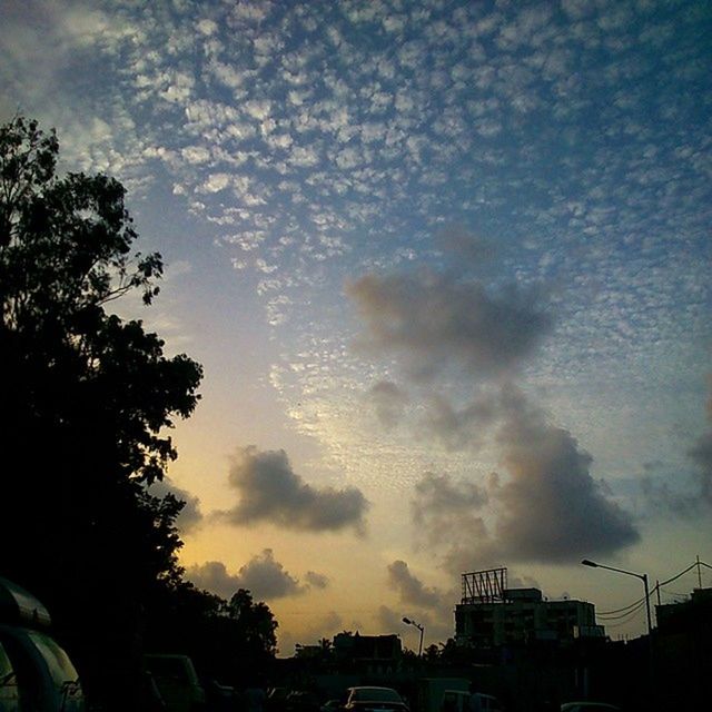 sky, cloud - sky, sunset, cloudy, silhouette, car, building exterior, tree, land vehicle, weather, transportation, built structure, architecture, mode of transport, cloud, overcast, dusk, storm cloud, dramatic sky, nature