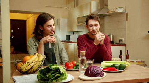 Portrait of young man having food at home