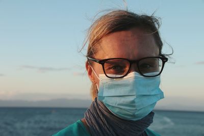 Portrait of woman wearing glasses against sky at sunset