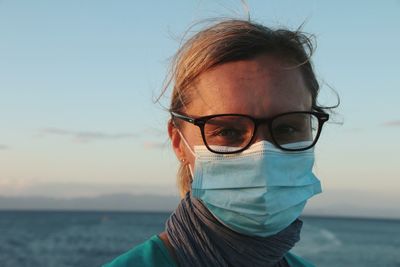 Portrait of woman wearing sunglasses against sky at sunset