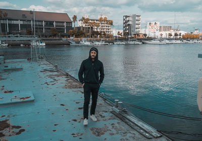 Portrait of man standing in boat against buildings