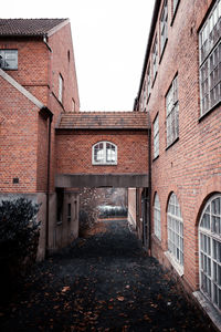 An old abandoned factory that used to make socks. a brick walkway through to the other building.