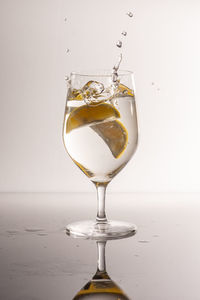 Close-up of wineglass on table against white background