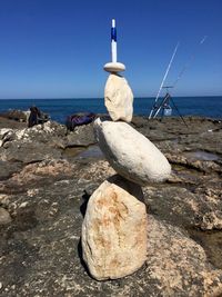 Stack of rocks on beach against clear sky