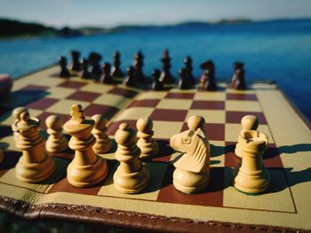 Close-up of chess board by sea