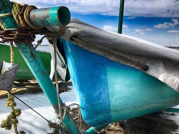 Close-up of boats moored in sea against blue sky