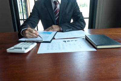 Rear view of man using laptop on table