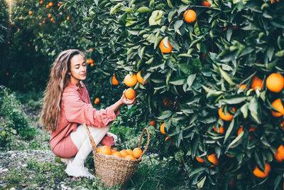 Young woman holding oranges