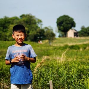 Portrait of smiling boy standing on field