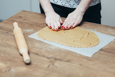 Midsection of person preparing cookies on table