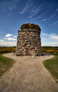 Stone structure on field against sky