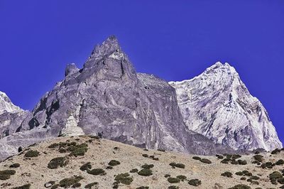 Low angle view of mountain against clear blue sky