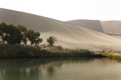 Scenic view of lake by mountain against sky