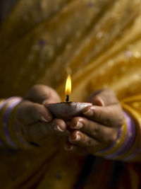 Midsection of woman holding diya