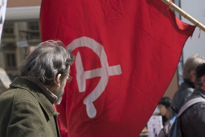 Rear view of people walking in front of flags