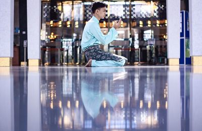 Man praying while sitting on floor