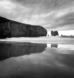 Rocks on sea shore against sky